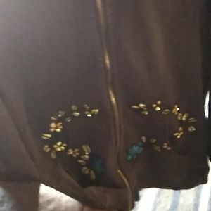 Black zip-up hoodie with flowers and vines on it